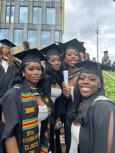 four women in graduation gowns posing for the camera