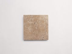 a small square tile piece on a white wall with no one in the room around it