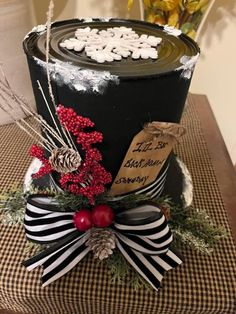 a black and white hat with red berries on top is sitting on a checkered table cloth