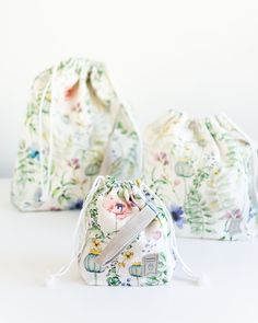 three small drawstring bags sitting next to each other on a white table top