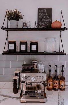 a coffee maker and some cups on a shelf