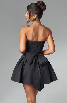 THE dress of the season has landed and you're going to be obsessed. Meet Katrina, our dreamy mini with a pretty, voluminous skirt and waist cinching bodice. Fastening with a zip to the back, tie with an oversized bow to complete the look for perfect feminine drama. 



Colour: Black.

Premium non-stretch cotton blend fabric.

Fully lined.

Strapless ruched bodice with boning.

Waist cinching.

Oversized tie to create bow detail to back.

Voluminous skirt with tulle lining.

Zip fastening to the reverse.

Mini length.

 Size: XS, S, M, L, XL, XXL Prom Mini Dress With Ruched Bodice, Chic Mini Length Dresses With Pleated Waist, Ruched Mini Length Bubble Dress For Evening, Evening Dresses With Ruched Voluminous Skirt, Ruched Mini Bubble Dress For Evening, Elegant Dress With Voluminous Skirt For Night Out, Chic Mini Dress With Pleated Waist For Cocktail, Evening Ruched Bubble Dress, Pleated Bodice Mini Dress For Prom