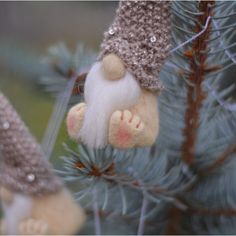 a gnome ornament hanging from a christmas tree with pine cones on the branches