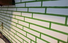 a green brick wall is painted white