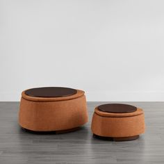 two stools sitting side by side on top of a hard wood floor in front of a white wall