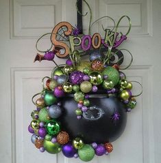 a halloween wreath hanging on the front door with decorations around it and spooky