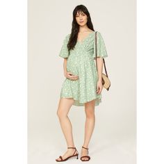 Green floral crepe (95% Polyester, 5% Spandex). Hourglass. Short sleeves. V-neck. Front button closure. 34.5" from shoulder to hemline. Imported. Floral Maternity Dress, Floral Maternity Dresses, Smocked Top, Pink Blush Maternity, Green Print, Maternity Dress, Red Floral, Maternity Dresses, Ruffle Hem