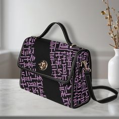 Elevate your style with our Classic Black Shoulder Bag, featuring an eye-catching purple pattern. Made of high-grade tarpaulin, this durable and stylish bag measures 10.63" (L) x 4.13" (W) x 7.87" (H), making it the perfect accessory for any occasion. Product Details: Material: High-grade tarpaulin - durable waterproof canvas . Design: Black edging, black handles, and shoulder straps secured with khaki stitching. Versatility: Use it as an iPad storage bag, business briefcase, college bag, leisur Ipad Storage, Hand Bags For Women, Business Briefcase, Bag Business, Black Handles, College Bags, Travel Handbags, Commuter Bag, Top Handle Bags