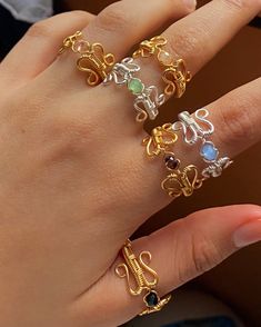 a woman's hand with four different rings on her fingers and one is wearing an elephant ring