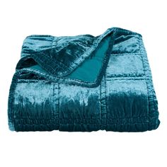 a blue blanket is folded on top of a bed