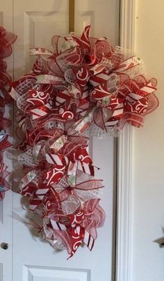 a red and white wreath hanging on the front door