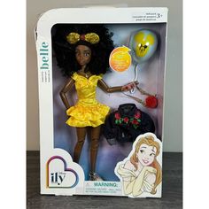 the doll is wearing a yellow dress and holding a tennis racket in her hand