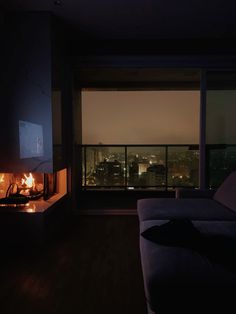 a living room filled with furniture and a fire place in front of a large window