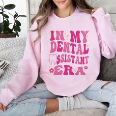 In My Dental Assistant Era Sweatshirt, Dental Era Shirt, Retro Dental Assistant Shirt, Dental Comfort Colors Shirt, Gift For Dental Assistant 🎉Celebrate the dental assistant era with our cozy and stylish In My Dental Assistant Era Sweatshirt. This sweatshirt pays homage to the retro dental assistant theme, perfect for those who love dentistry. The Dental Era Shirt features a unique and nostalgic design that showcases your passion for dental assisting. It also makes a great gift for dental assis Pink Long Sleeve Shirt With Letter Print, Funny Long Sleeve Shirt With Letter Print, Pink Long Sleeve Shirt With Funny Print, Long Sleeve Pink Shirt With Text Print, Dental Assistant Aesthetic, Dental Assistant Study, Dental Assistant Shirts, Dental Assisting, Dental Aesthetics