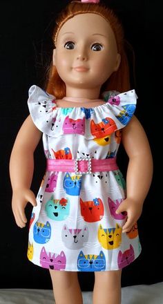 the doll is wearing a dress with cats on it