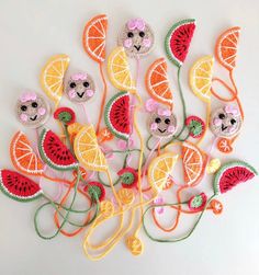 a bunch of fruit and animals made out of crochet on a white surface