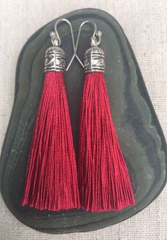 Chic dark red tassel earrings!  They would add a pop of color to any outfit for any occasion.  Dress them up or down.  They are timeless and versatile.  They are lightweight, fun and unique!The tassels measure 2 1/8” long by 1/4” wide.  They hang from simple silver ear wire hooks.  Overall drop length is about 2 1/4”.  Metal is allergy free plated silver.These are my latest creation!  I have them available in many colors!  Find them all under the category tassel earrings in my shop.Thanks for st Red Yarn Earrings, Red Tassel Drop Earrings For Pierced Ears, Red Tassel Drop Earrings Gift, Elegant Red Tassel Earrings As Gift, Elegant Red Tassel Earrings For Gift, Red Tassel Earrings For Gift, Red Dangle Tassel Earrings As Gift, Red Dangle Tassel Earrings For Gift, Red Dangle Tassel Earrings With Latkans