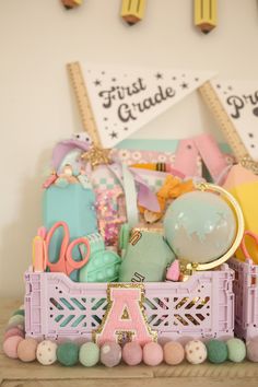 there is a pink basket filled with lots of items on top of a shelf next to some pegs