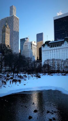 the city is covered in snow and ice as people walk on the frozen riverbank