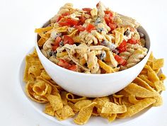 a white bowl filled with pasta salad next to tortilla chips