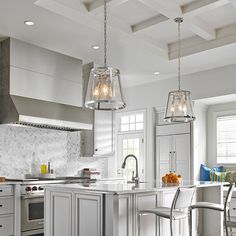 a kitchen with two pendant lights hanging from the ceiling