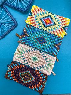 beaded purses are lined up on a blue surface