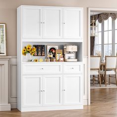 a white cabinet with sunflowers and pictures on the top is in front of a dining room table