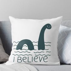 a pillow that says i believe with an image of a dinosaur swimming in the water