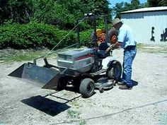 a man standing next to a machine in the dirt