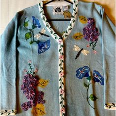 a blue sweater with flowers and butterflies on it