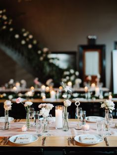 the table is set with white flowers and candles