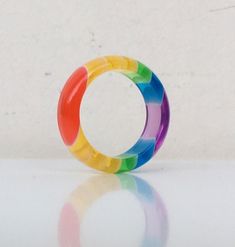 a multicolored plastic ring sitting on top of a white table next to a wall