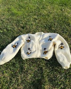 a sweater with bees on it laying in the grass