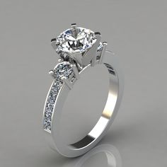 a white gold engagement ring with three stones on the side and an accent diamond in the center