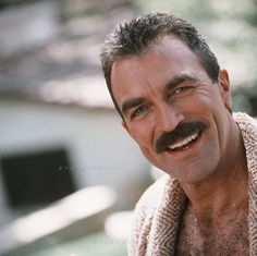 a man with a moustache on his face and a towel around his neck