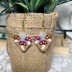 a potted plant sitting on top of a table next to a pair of earrings