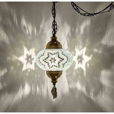 a chandelier hanging from a chain in front of a wall with snowflakes on it