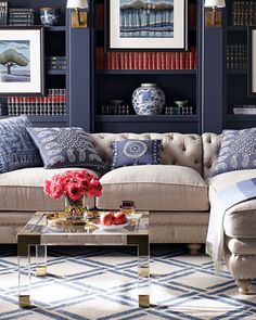 a living room filled with furniture and bookshelves covered in blue and white decor