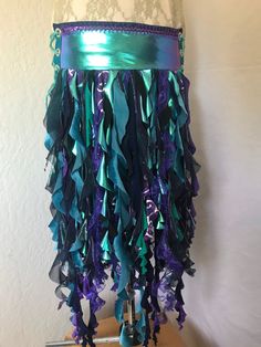 This one of a kind mermaid belt skirt is a unique wearable art piece that is made from reclaimed fabrics and comes with an adjustable pocket.  Wearing this garment will give you a nigh irresistible urge to spin around and shimmy and smile. The Teal Purple Iridescent belt is made from an amazingly shiney fabric that shows teal, purple or green depending on the angle of the light and is trimmed out with a fluffy purple sequined trim and seaweed-y spirals that accent the belt colors and dance and flow at your slightest movement while not hampering your motion.  It is a two piece belt that is fastened on the body with lacings on both hips for maximum flexibility in sizing.  It is lined with cotton fabric for comfort. This belt measures about 26.5 inches in length and is approximately 5.5 inche Mermaid Belt, Iridescent Mermaid, Belt Skirt, Princess Core, Purple Skirt, Purple Outfits, Mermaid Costume, Skirt Belt, Lace Border