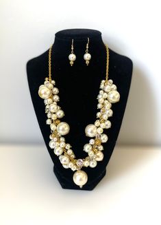 "Chic cluster ivory pearl necklace with matching earrings. This bib cluster necklace is made with dangle cream glass pearls different size on a gold  tone chain with some sparkly crystal, gold beads and finished with lobster-claw clasp.  Coordinate this clustered necklace with any ensemble from business casual to everyday wear. Well balanced pearl to fit any style.  Approximate length:17+3\" adjustable chain (43+7 cm) Perfect necklace for bridesmaids!" Cream Pearl Chain Jewelry, Cream Dangle Jewelry For Party, Cream Pearl Jewelry For Party, Party Jewelry With Cream Pearls, Gold Bridal Necklace With Pearl Charm For Party, Party Cream Pearl Jewelry, Gold Dangle Pearl Necklace For Party, Cream Pearl Drop Jewelry For Anniversary, Gold Pearl Jewelry Sets For Anniversary