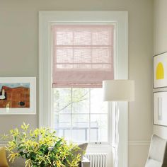 a living room filled with furniture and a window covered in pink roman shade blindes