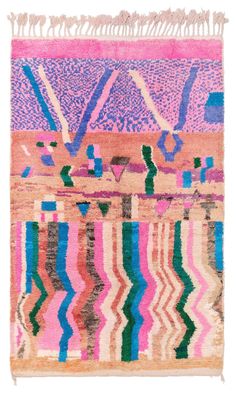 a pink and blue rug with fringes on it's edges, in front of a white background