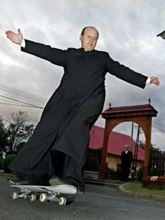 a man riding a skateboard down the middle of a street with his arms outstretched