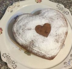 a heart - shaped cake on a plate with powdered sugar in the shape of a heart