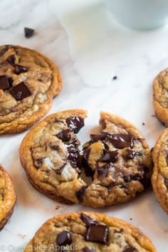 chocolate chip cookies on a table next to a glass of milk