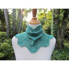 a white mannequin with a green crochet scarf on it's neck