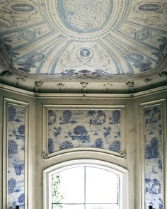 a window in a room with blue and white wallpaper