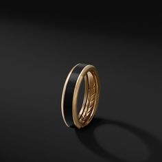 a black and gold wedding ring on a dark background