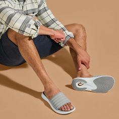 Drawing inspiration from sporty sneakers, the Komo Slide combines the ease of a slip-on with the comfort of OluKai. Featuring a cushioned footbed and a snug, water-resistant strap, this slide is designed for effortless entry and superior comfort. The name 'Komo,' meaning "to enter" or "to go into," aptly reflects the slide's readiness to accompany you in every step of your day, whether you're hitting the beach or the streets. Key Features: Water-Repellent Material: Crafted with water-repellent s Relaxing Backyard, Mens Slide Sandals, Sporty Sneakers, Beach Slides, Promotional Products Marketing, Men's Sandals, Plus And Minus, Beach Sandals, Mens Sandals