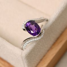 This ring features a 6*8mm oval cut amethyst and sterling silver finished with rhodium. Customization is available. It is made by hand, and it will take about 7 days to finish the ring after your payment is completed. Main stone: amethyst Amethyst weight: Approx 1.25 ct Metal type: sterling silver finished with rhodium Accent stone: cz Customization is available, I also can make it with 14k solid gold (white or yellow or rose) and diamond accent stone, just feel free to contact me. Any question, Oval Amethyst Ring, Hand Jewelry Rings, Gemstone Engagement Ring, Oval Cut Ring, Amethyst Ring Engagement, Ring Purple, Purple Rings, Purple Amethyst Ring, Alexandrite Engagement Ring